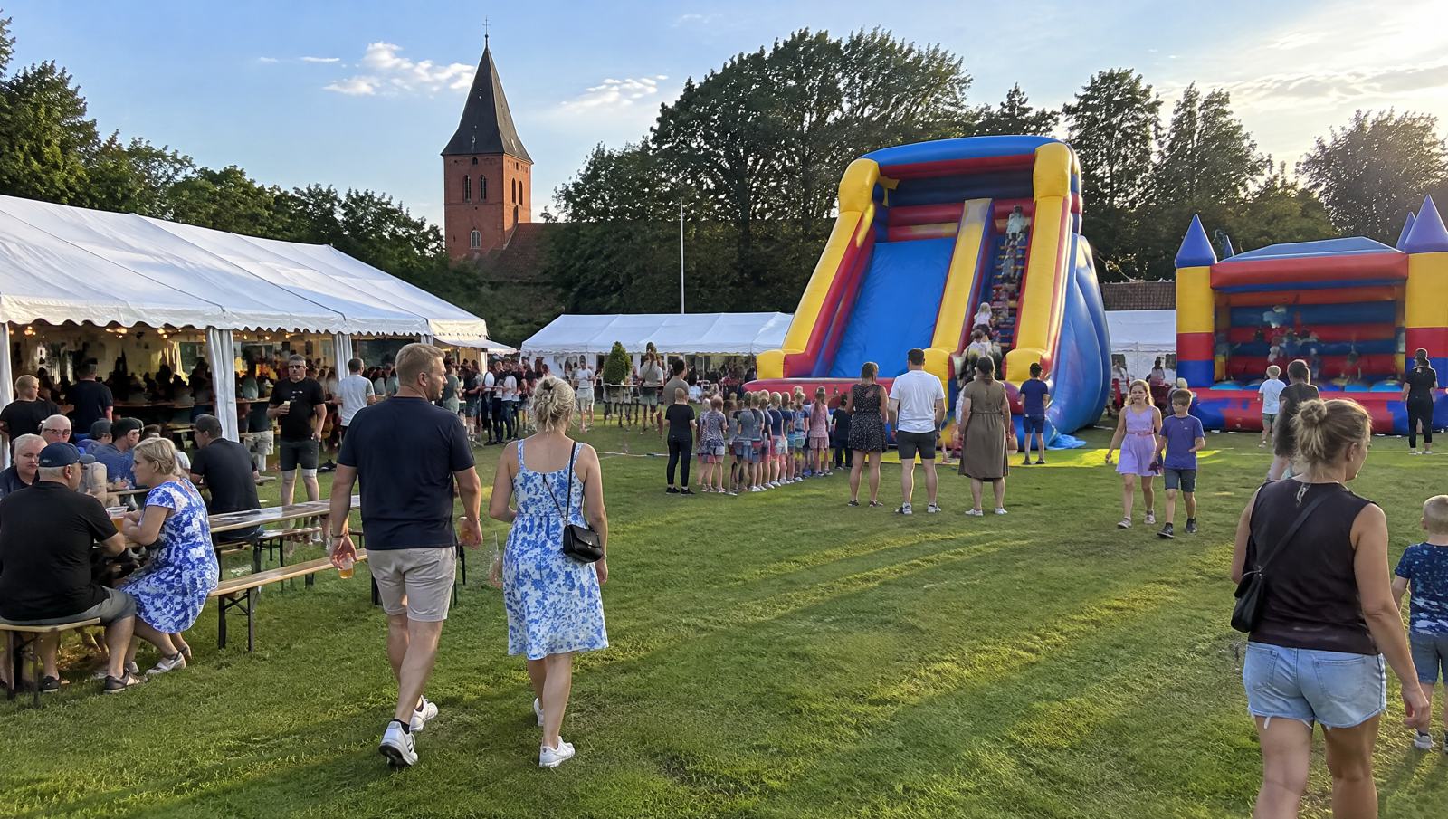 Hoppeborg og oppustelig rutsjebane til byfest på en græsplæne